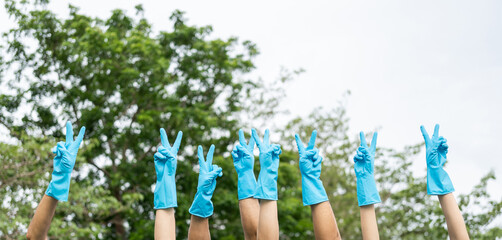 Happy volunteer people group charity with garbage bags cleaning up in park. Corporate social...