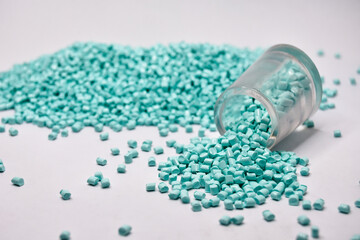 turquoise green masterbatch granules on a white background, this polymer is a coloring agent for...