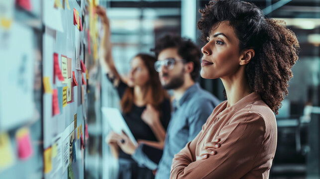 Professionals using post-it notes for strategic planning and organization in a modern office.