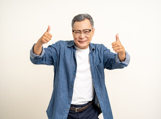 Fototapeta premium Handsome asian mature old man standing thumbs up on isolated white background. Happy Portrait of cheerful smiling senior asian man looking at camera. Mature People and lifestyle