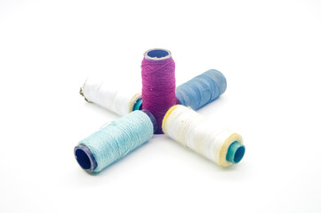 several rolls of colorful sewing thread arranged isolated on white background