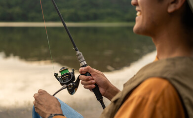 Enjoy moment of Handsome man fishing as a leisure activity during his vacation at the lake on...