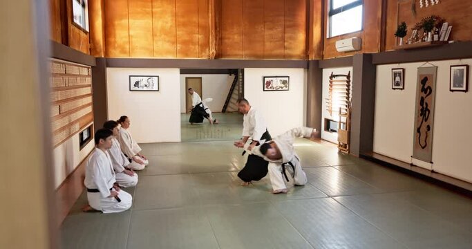 Students, aikido or sensei teaching Japanese martial arts in dojo for practice, body movement or self defense. Combat demonstration, black belt or people training for fighting, education or class
