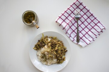 arroz, yerba mate, servilleta y verduras salteadas en un plato con fondo blanco