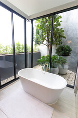 Luxury bathroom with white bathtub by the window, concept in a modern house