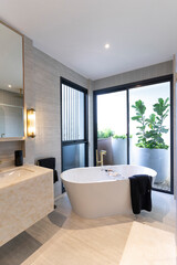 Luxury bathroom with white bathtub by the window, concept in a modern house