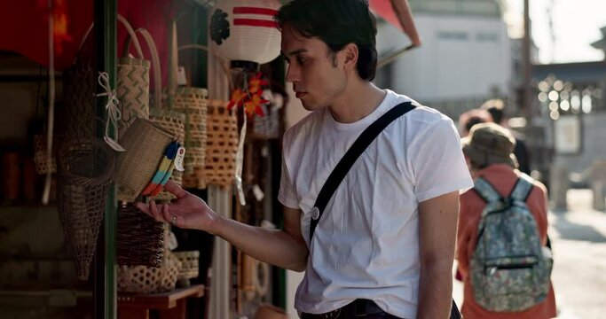 Walking, shopping and Japanese man in the city exploring on a summer vacation, adventure or holiday. Travel, sightseeing and young male person commuting in street in Yokohama town on weekend trip.