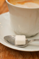 coffee cup and sugar cube on table
