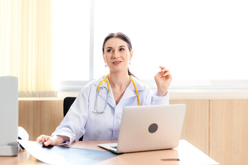 Doctor women working and checking disease examination results on laptop at desk in front hospital.  Young female medical in working room