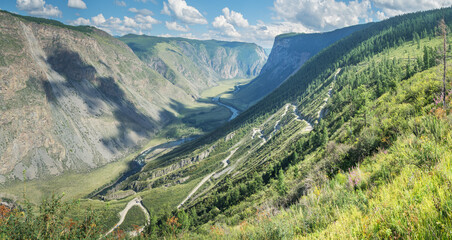 A dangerous road descends into a deep gorge. Mountain pass. Travel and summer vacation.	