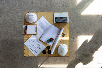 Engineer and worker table meeting at the construction building site with floor plan for real estate...