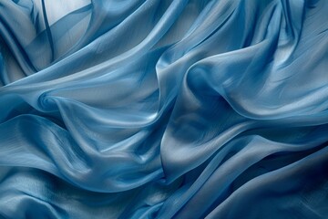 Fototapeta premium Luxurious silky blue fabric flowing, creating an elegant and smooth texture with soft folds and a sense of serenity.