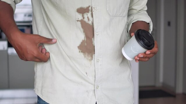  men hands with spilled coffee over his shirt