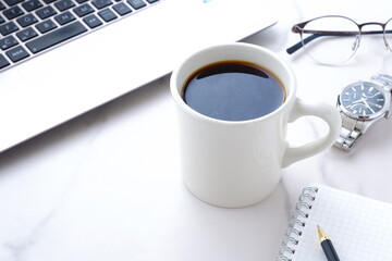 Obraz na płótnie Canvas コーヒーを飲みながらノートパソコンでデスクワーク中のイメージ 