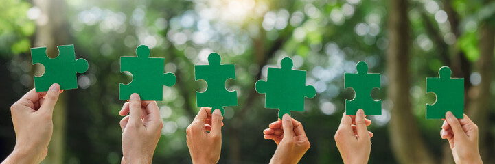 World environment day and ESG Concept of teamwork and partnership Hands join Jigsaw puzzle pieces...