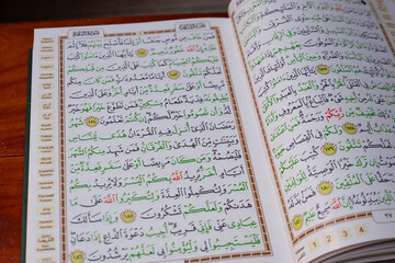 Opened Quran on Muslim prayer mat indoors
