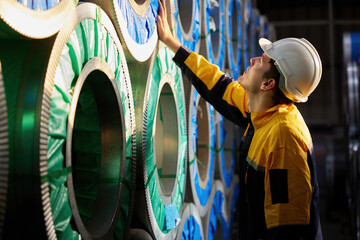 worker or technician checking a roll of industrial aluminum metal material in the factory - obrazy, fototapety, plakaty