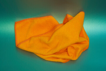 Orange microfiber cloth on a green background.