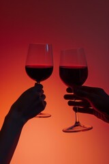 Two glasses with red wine in the hands of people on a dark red background.