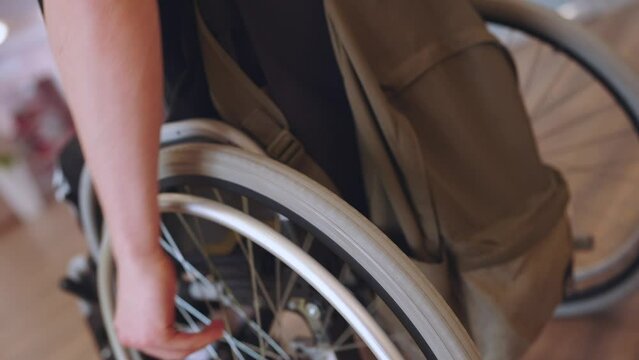 Close-up of hands rotating wheelchair wheels, wheelchair movement
