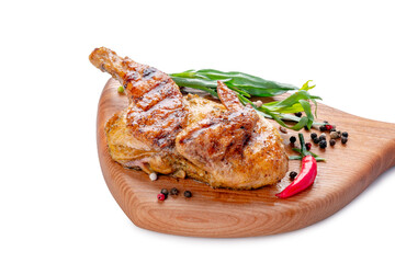 Half of a fried small chicken on a wooden board on a white background