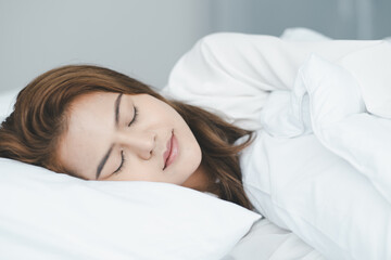 Women sleeping on bed with white blanket and sleepwear