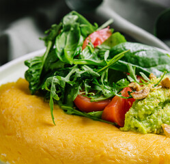 Omelette Served with Avocado puree and Cherry Tomatoes close up