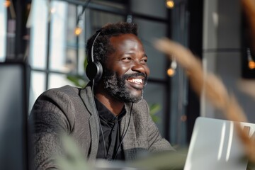 Happy man with headphones working on laptop, capturing enjoyment in modern work life