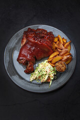 Baked pork knuckle with vegetables. Cabbage salad. Homemade grilled potatoes. Traditional beer snack. Vertical photo.Top view. Copy space.