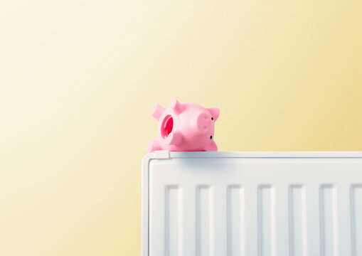 empty piggy bank upside down on radiator, yellow background, heating costs and energy prices