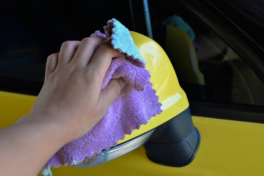 Hand cleaning wiping car side mirror in the carwash ,car care.