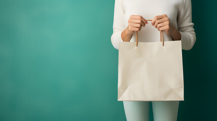 Woman holding paper shopping bag on green background