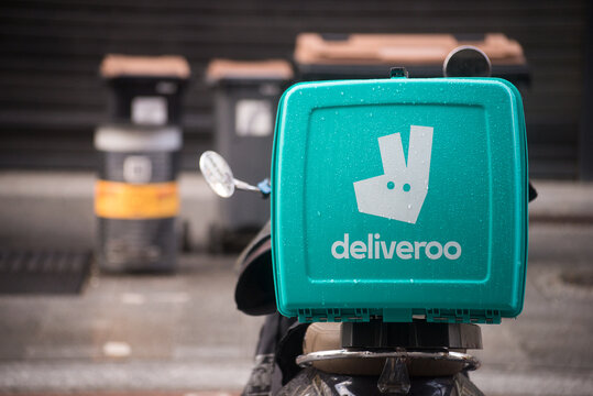 Mulhouse - France - 25 february 2024 - Closeup of deliveroo logo on blue plastic backpack on motorcycle parked  in the street
