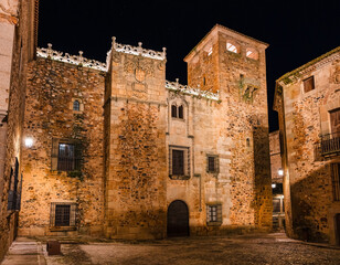 Fototapeta na wymiar Stunning medieval stone buildings and palaces at night in Caceres, Spain