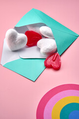 Letters filled with hearts and lollipops with a rainbow on a pink surface.