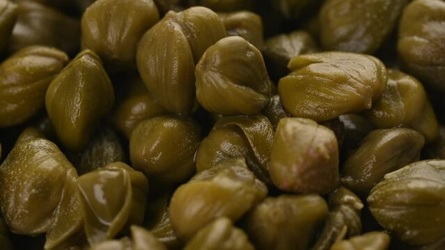 Pickled capers close up full frame as background. Loopable Capres Video. Rotating video