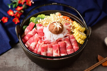 Fat beef rolls and vegetable ingredients placed in black hot pot