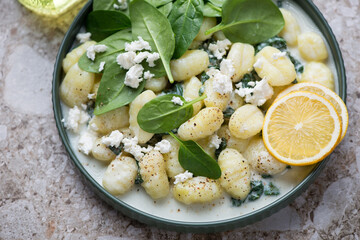 Plate of potato gnocchi with spinach and feta cheese, horizontal shot, middle close-up