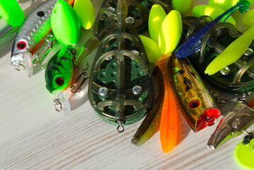 Fishing tackle on a wooden background. Float, flatt, silicone bait, spinner.