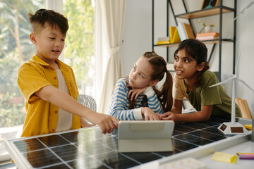 Schoolgirls listening to their classmate showing entertaining video on green energy
