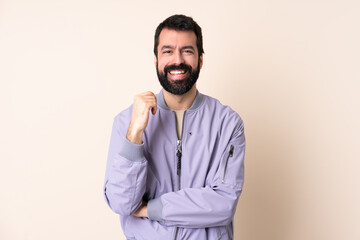 Obraz premium Caucasian man with beard wearing a jacket over isolated background laughing