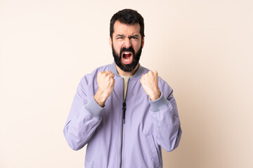 Caucasian man with beard wearing a jacket over isolated background frustrated by a bad situation