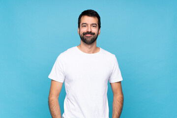 Young man with beard  over isolated blue background laughing