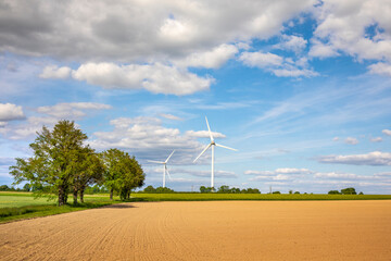 Paysage de campagne et éolienne au milieu des champs en France. - 745061677