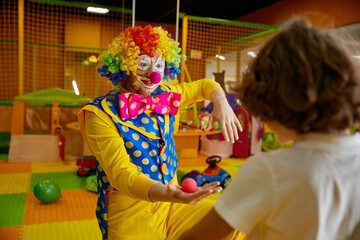Playful clown showing tricks with nose carnival decoration at birthday party