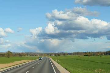 Expansive Country Road Under a Dramatic Sky on a Bright Spring Day