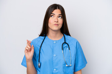 Young Brazilian nurse woman isolated on white background with fingers crossing and wishing the best