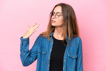 Young caucasian woman isolated on pink background with tired and sick expression