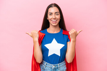 Super Hero Caucasian woman isolated on pink background with thumbs up gesture and smiling
