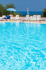 Swimming pool on sunny day by sea